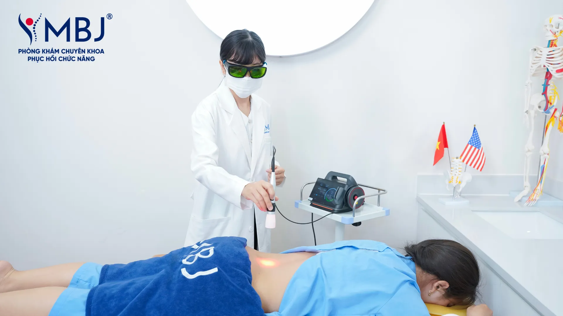 Kỹ thuật viên vật lý trị liệu thực hiện điều trị cho bệnh nhân bằng máy laser cường độ cao thế hệ IV