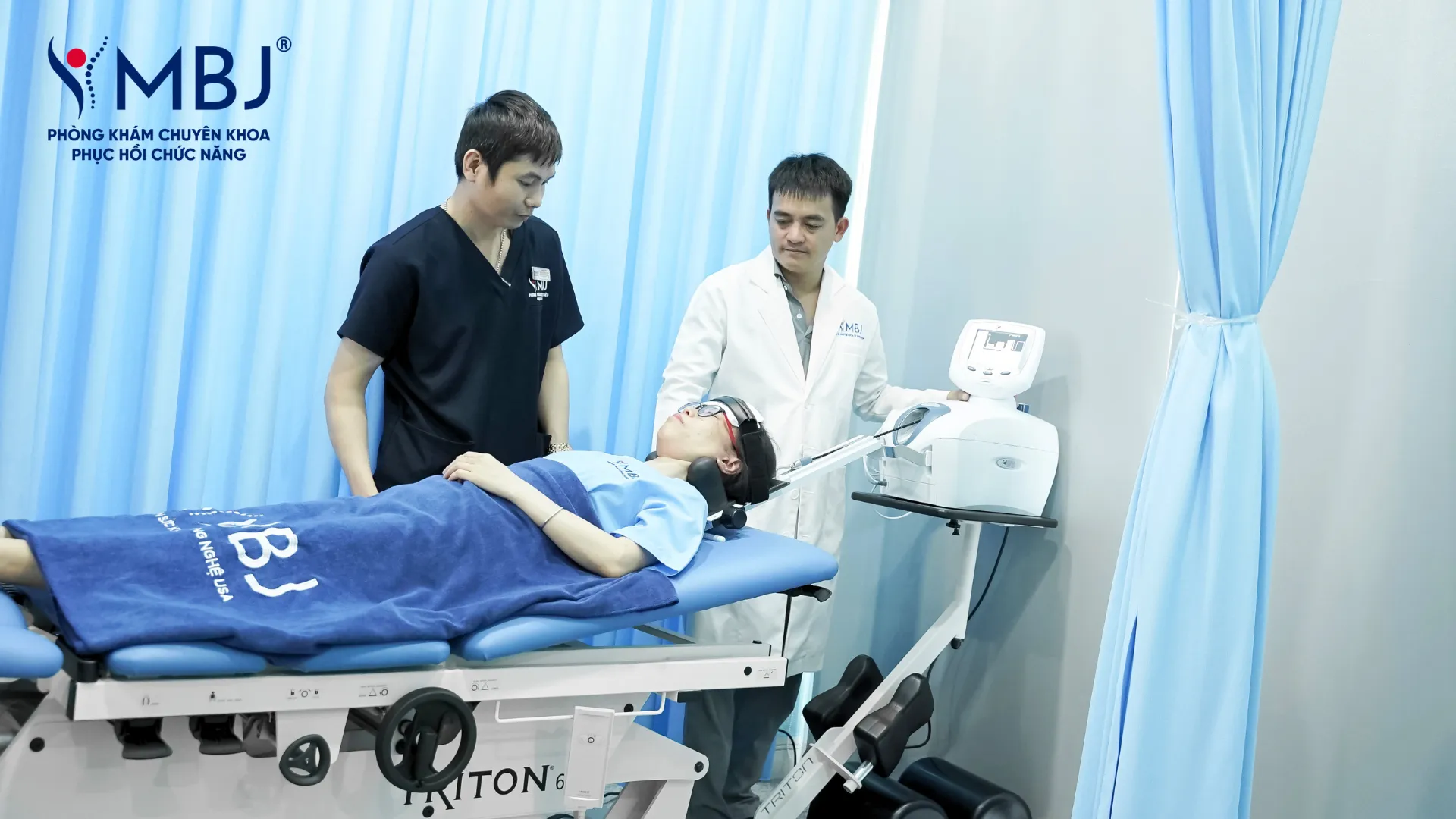 Bác sĩ và kỹ thuật viên MBJ vận hành máy kéo giãn giảm áp cột sống điều trị thoái hóa thắt lưng