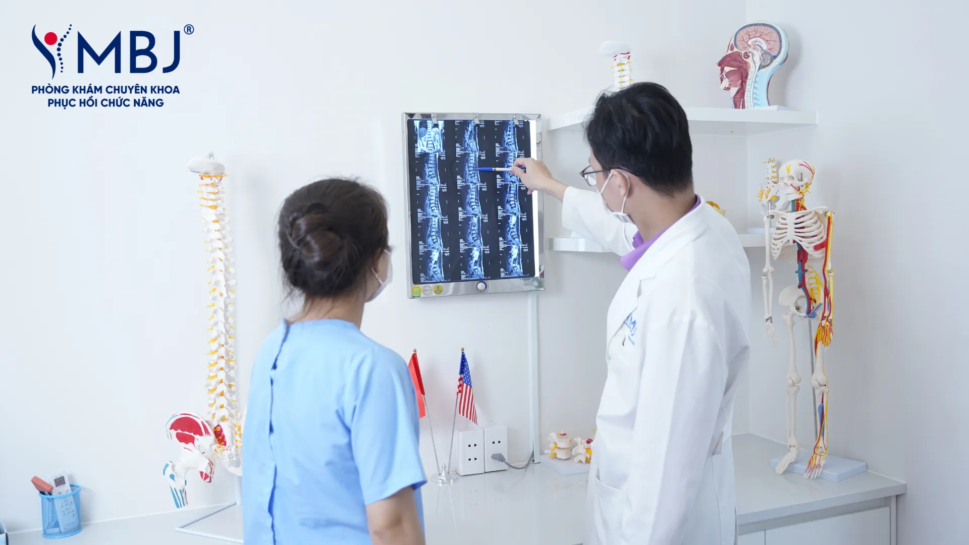 Bác sĩ MBJ khám vận động thắt lưng và đọc phim chụp cho người bệnh thoái hóa cột sống
